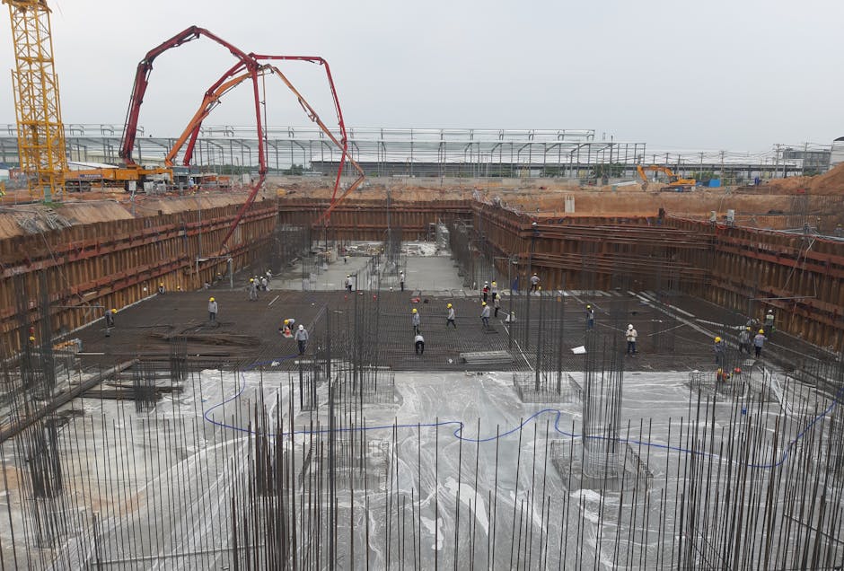 Construction site with workers setting foundation and steel reinforcements